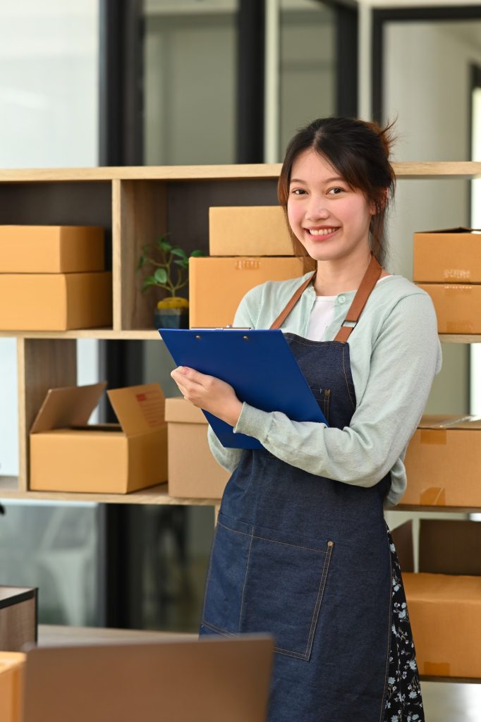 Happy startup small business owner working at warehouse for online selling.